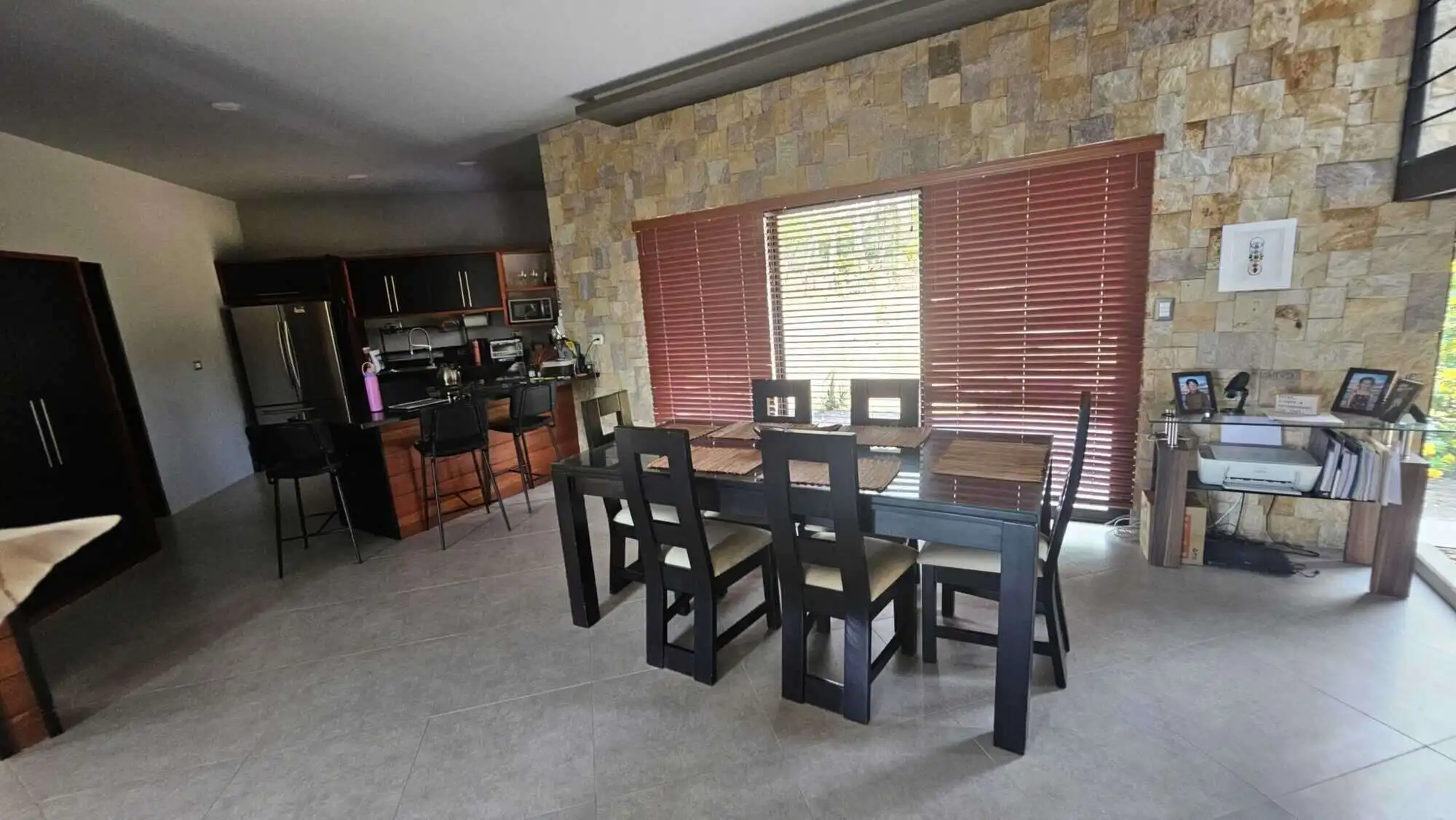 Elegant dining room with large windows and wooden blinds in Miramar, Costa Rica.