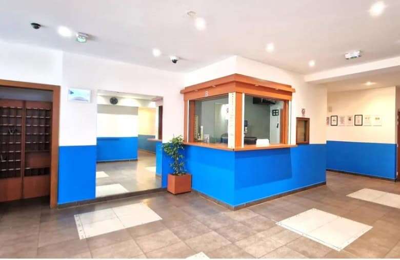 Modern hotel lobby with blue accents and reception desk.