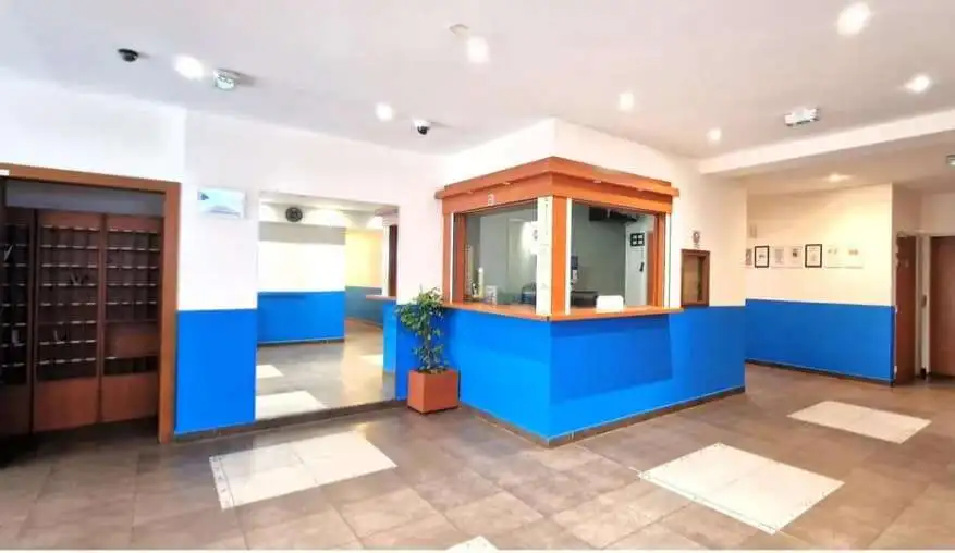 Modern hotel lobby with blue accents and reception desk.