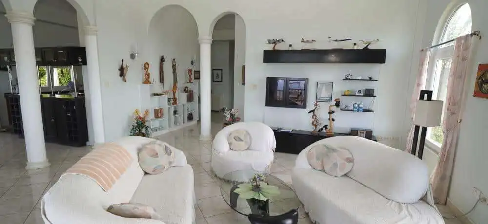 Elegant living room with white sofas and modern decor in a luxury villa.