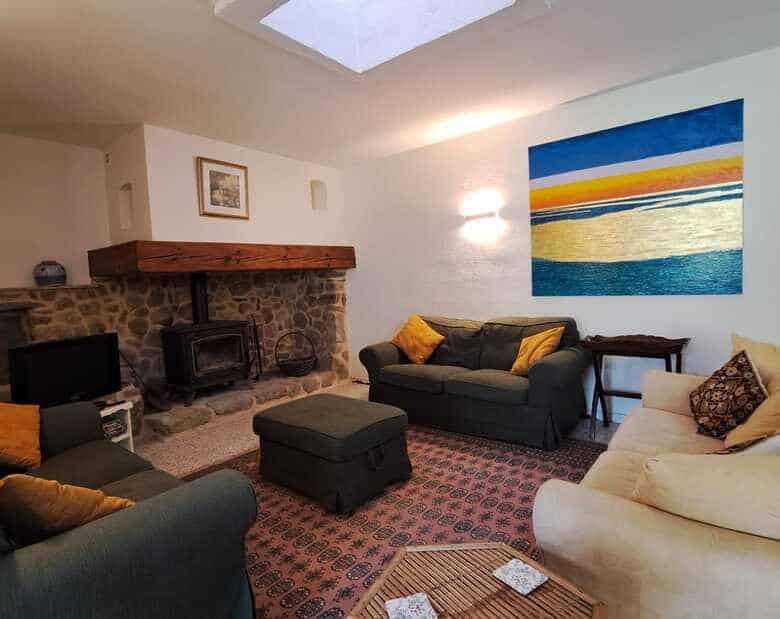 Cozy living room with modern furnishings and a stone fireplace. Bright space with colorful artwork a.