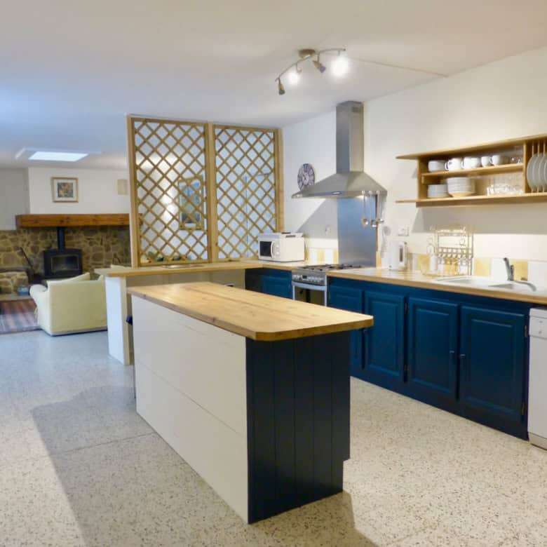 Elegant country estate kitchen in Branoux les Taillades, Occitanie. Modern design with blue cabinetr.