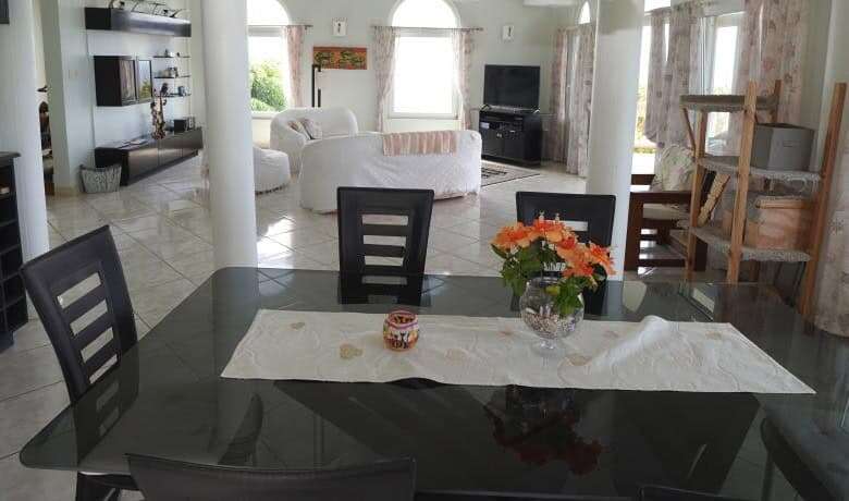 Spacious living room with modern furniture and large windows in a luxury villa in Harmony Hall, Pros.