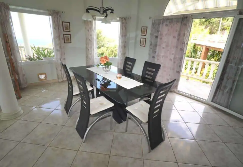 Elegant dining room with large windows and balcony view.