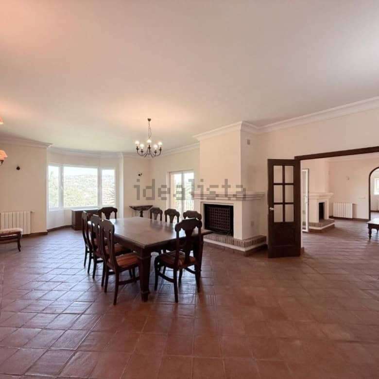 Elegant living room with spacious dining area and fireplace in a luxurious Sotogrande villa.