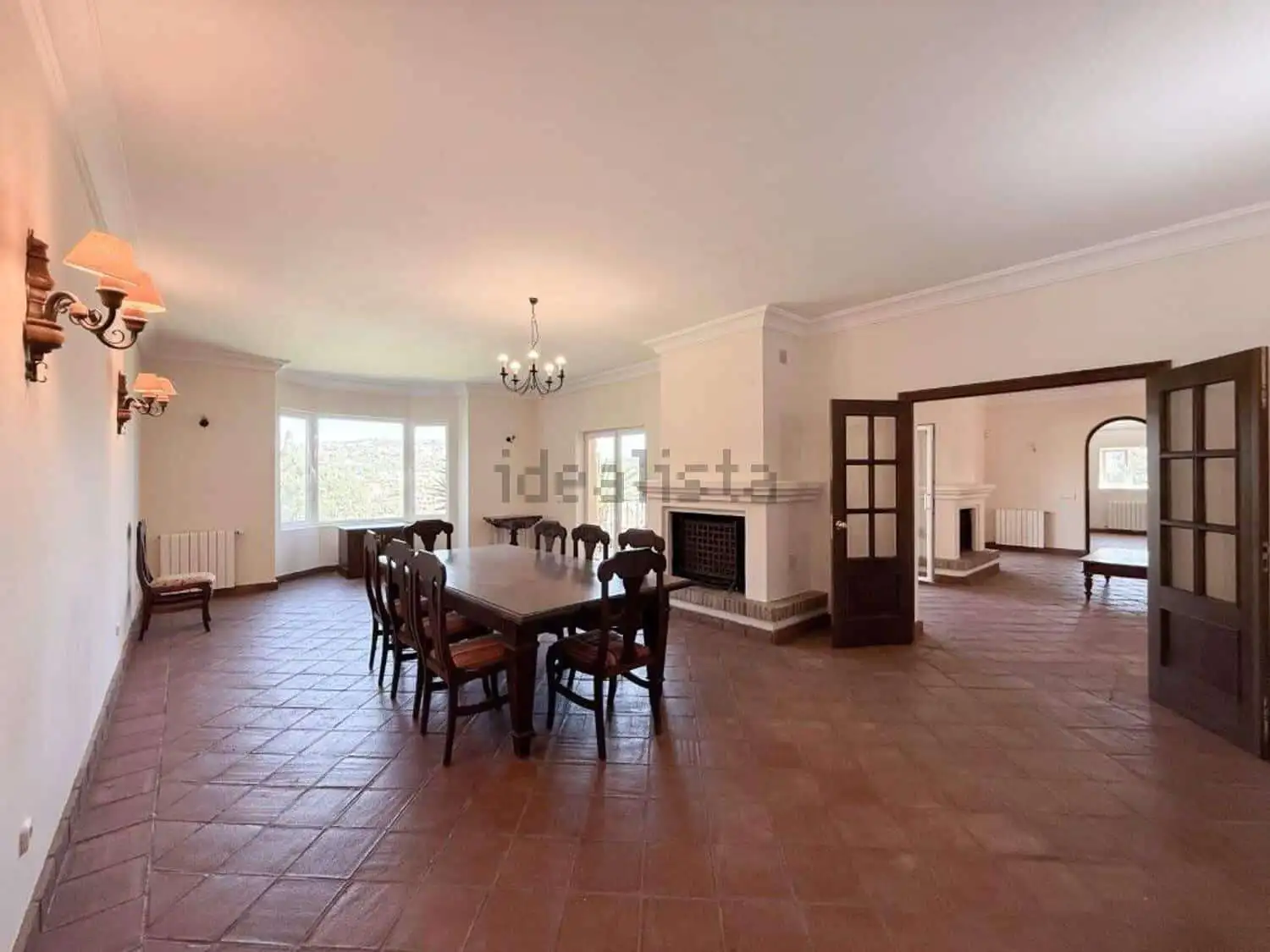 Elegant living room with spacious dining area and fireplace in a luxurious Sotogrande villa.
