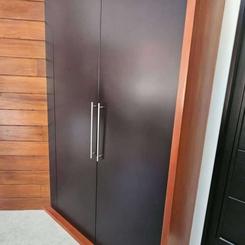 Stylish black and wood storage cabinet with sleek handles, ideal for contemporary home interiors.