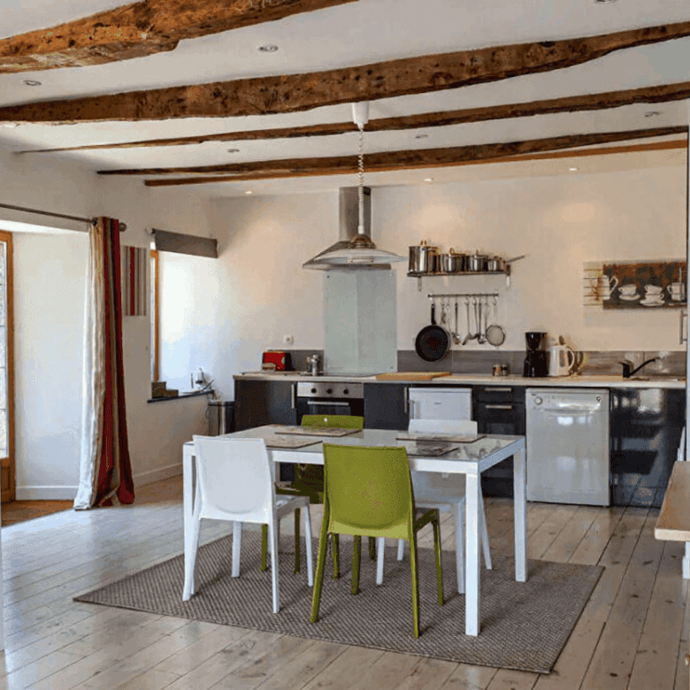 Beautiful interior of a Brittany gite with modern kitchen and rustic wooden beams.