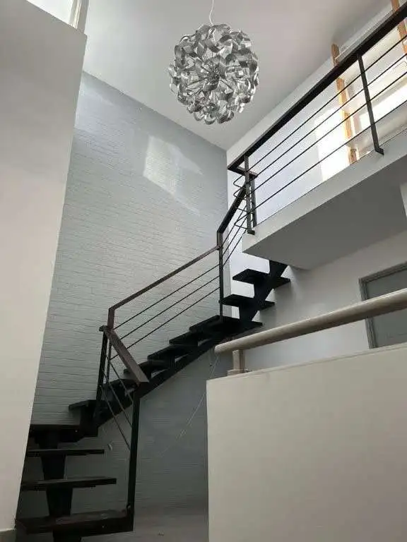 Elegant staircase with black treads and contemporary design in a bright home interior.
