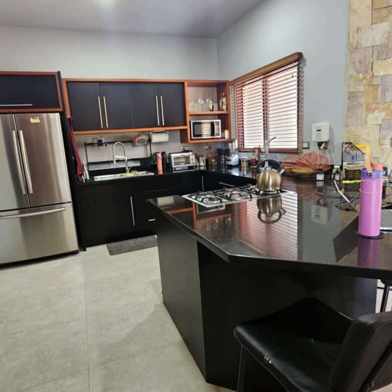 Modern kitchen with stainless steel appliances and wooden cabinets in Miramar de Puntarenas.