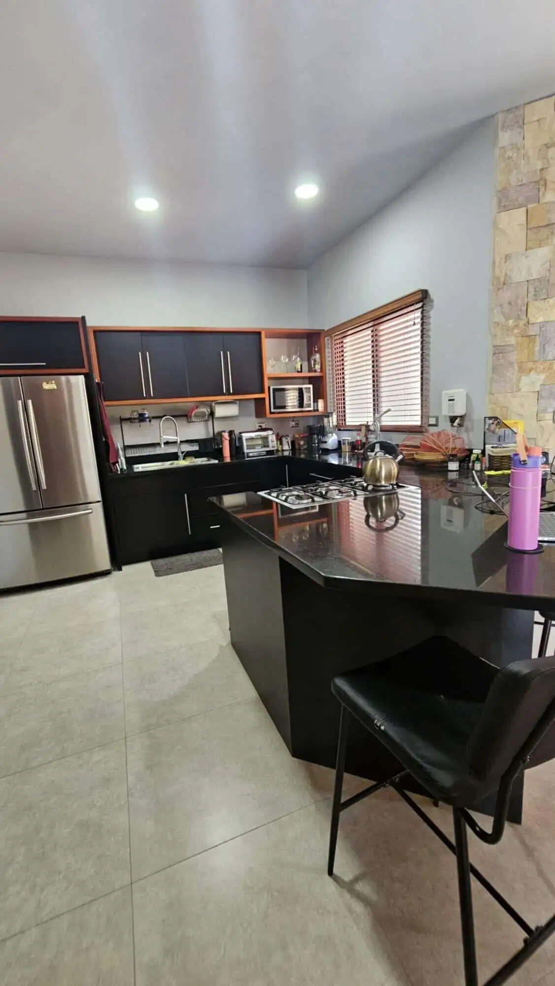 Modern kitchen with stainless steel appliances and wooden cabinets in Miramar de Puntarenas.