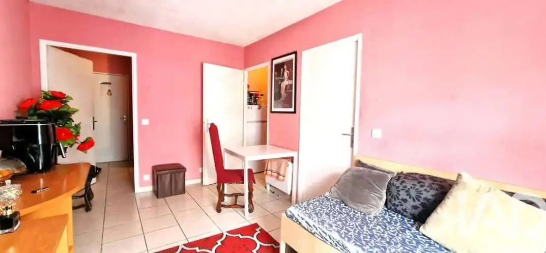 Interior view of a cozy 1-bedroom apartment in Paris with pink walls and modern furnishings.
