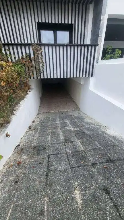 Contemporary villa entrance with driveway and balcony in Setubal, Portugal.