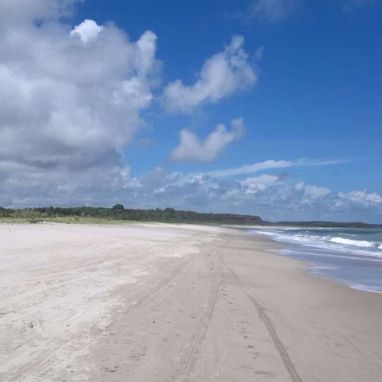 Scenic beach in Lucena featuring pristine white sand and clear blue skies, perfect for relaxation an.