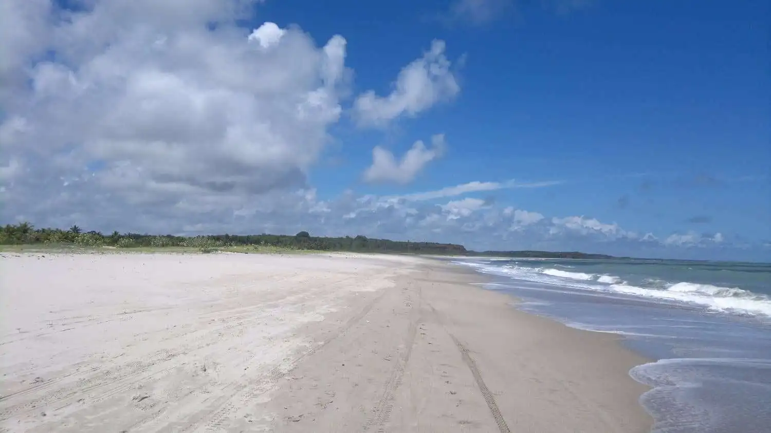 Scenic beach in Lucena featuring pristine white sand and clear blue skies, perfect for relaxation an.