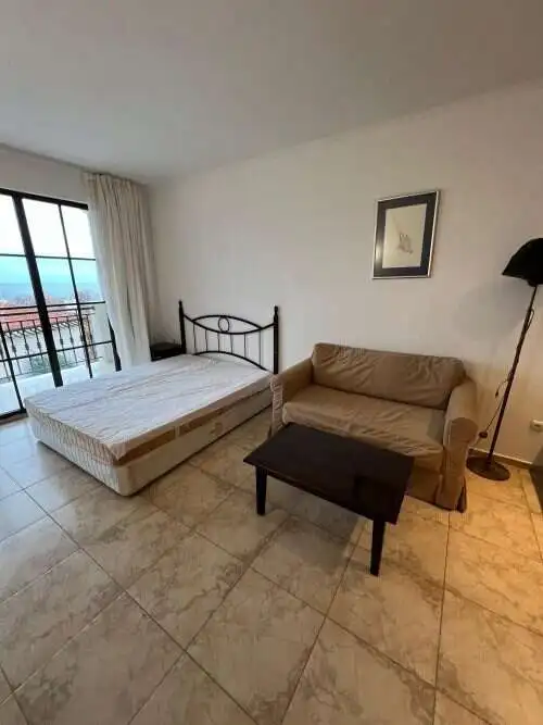 Interior of a studio apartment with sea view, sofa, and balcony in Obzor.