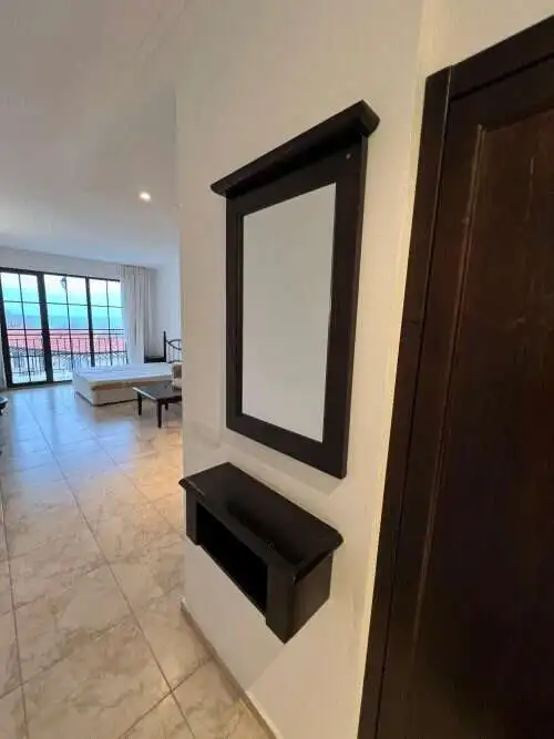 Sea view studio apartment interior with large window and balcony in The Cliff Beach & Spa, Obzor.