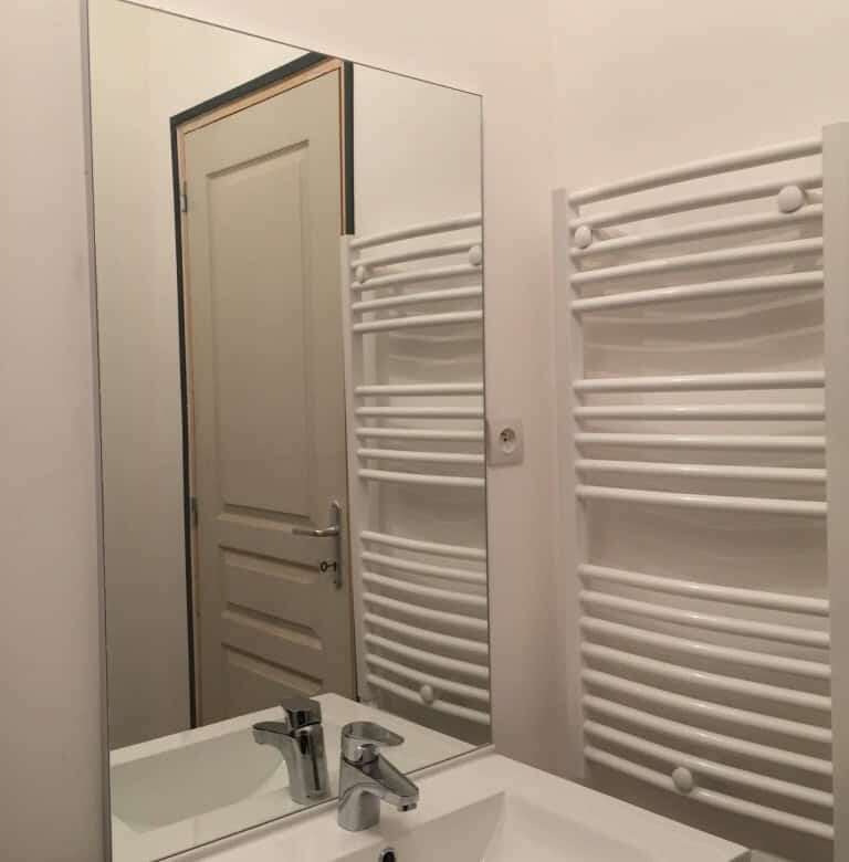 Bathroom sink with mirror and heated towel rail in seaside house.