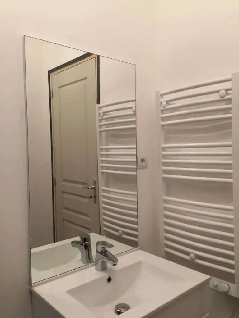 Bathroom sink with mirror and heated towel rail in seaside house.