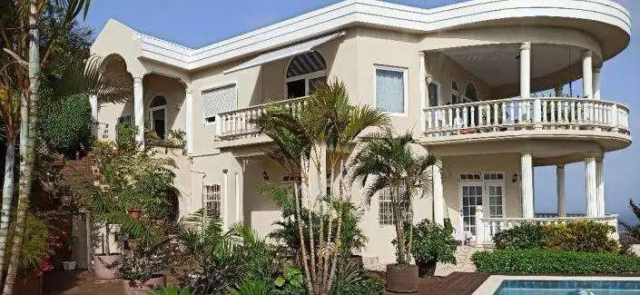 Elegant white villa with balconies and lush garden in Prospect, St. Vincent.