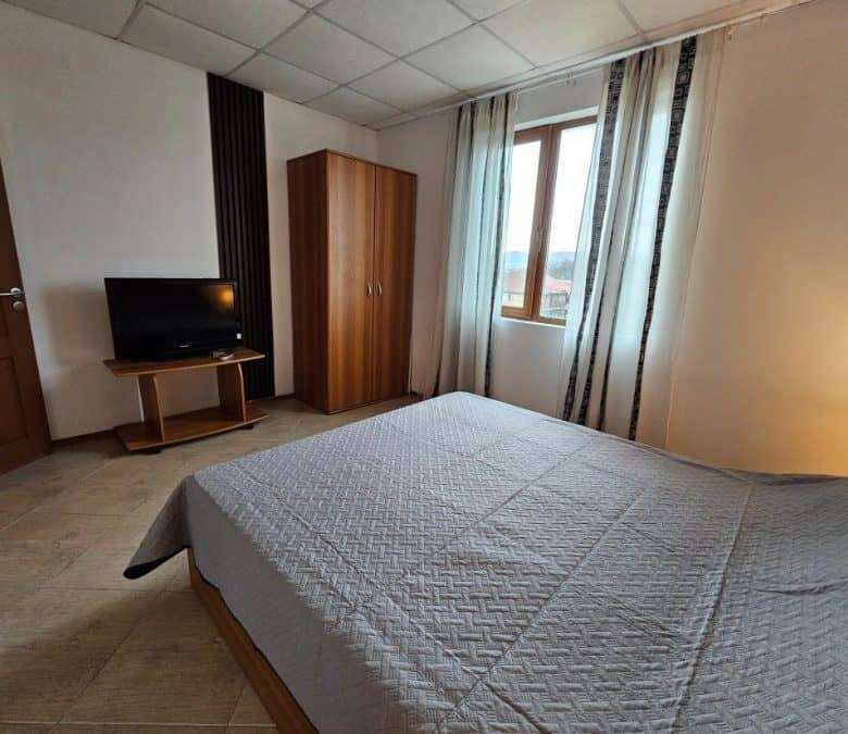 Bright bedroom with large window and modern furnishings.