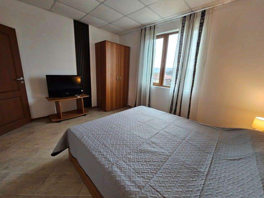 Bright bedroom with large window and modern furnishings.