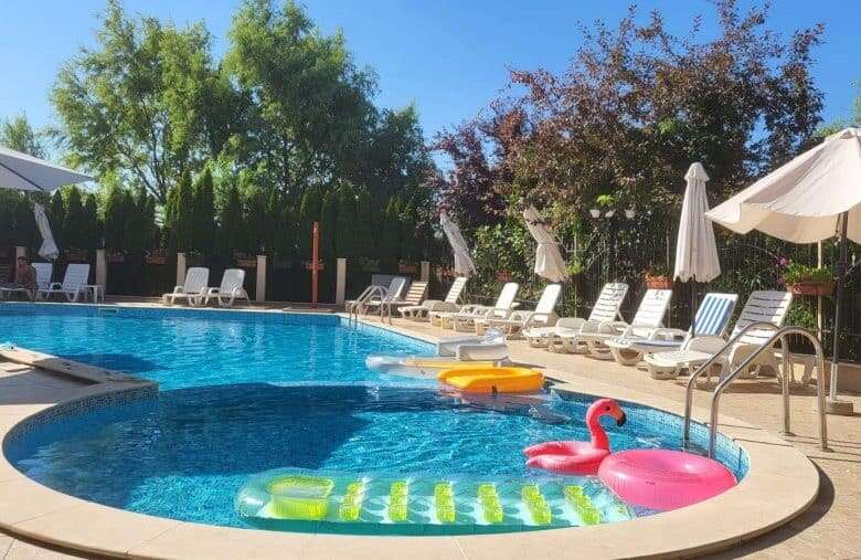 Pool area with lounge chairs, umbrellas, and floating inflatables in Sunny Beach.