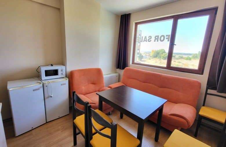 Bright living room with sofa and dining area near large window.