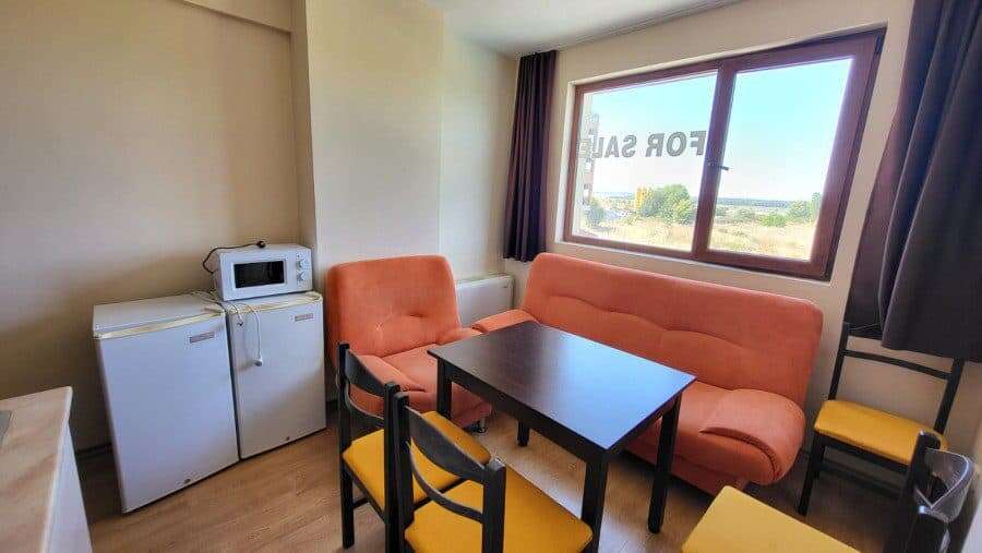 Bright living room with sofa and dining area near large window.