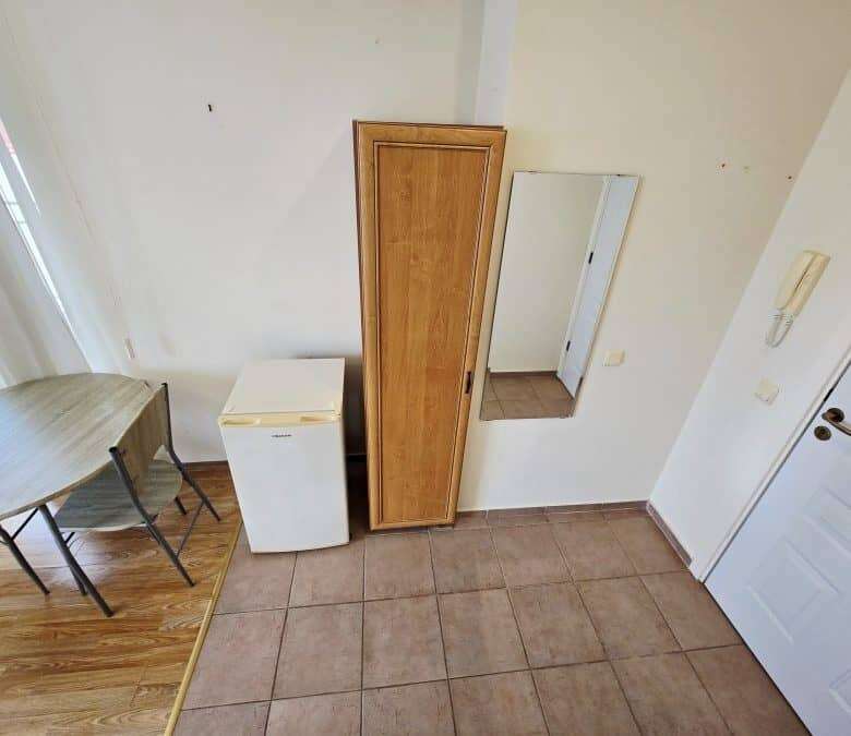 Cozy studio space with basic furnishings, including a wardrobe and mirror, in Nessebar Fort club.
