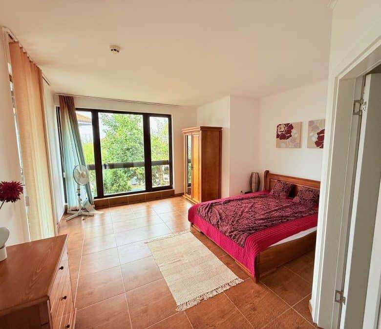 Spacious bedroom featuring a large window and balcony overlooking lush greenery in Kosharitsa, Bulga.