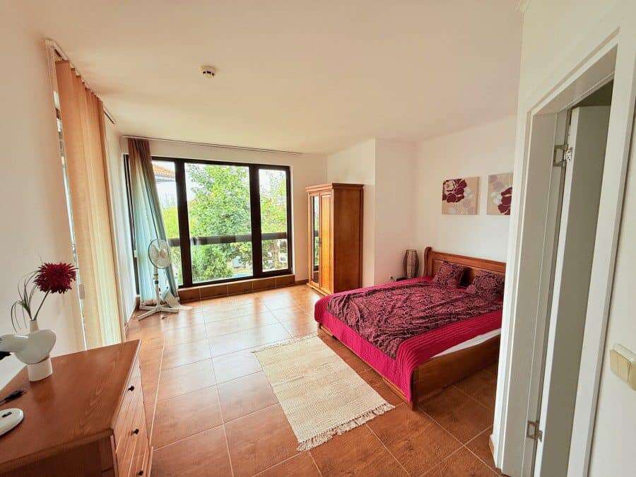Spacious bedroom featuring a large window and balcony overlooking lush greenery in Kosharitsa, Bulga.