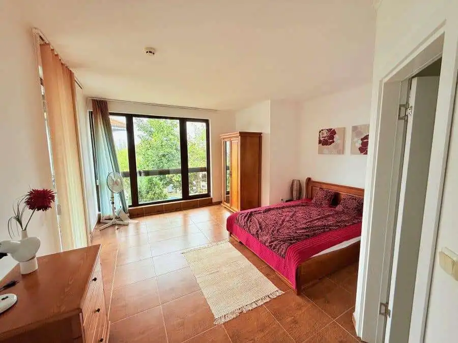 Spacious bedroom featuring a large window and balcony overlooking lush greenery in Kosharitsa, Bulga.