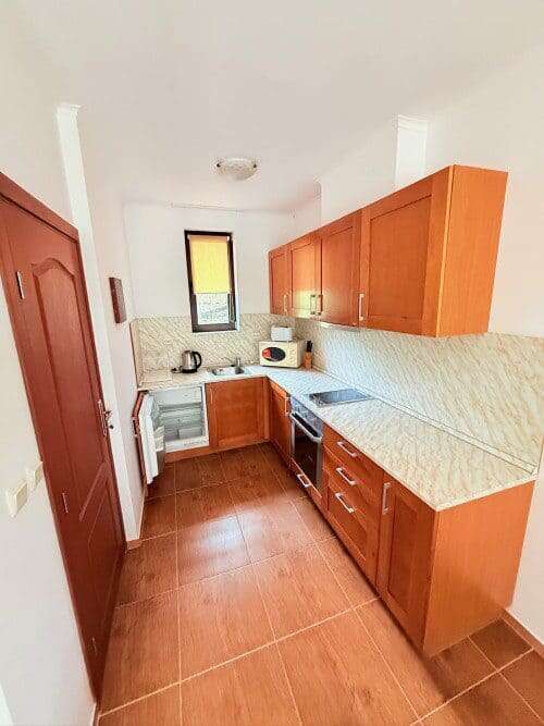 Modern kitchen with wooden cabinets and appliances in Bay View Villas, Kosharitsa, Bulgaria.
