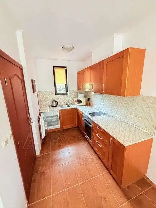 Modern kitchen with wooden cabinets and appliances in Bay View Villas, Kosharitsa, Bulgaria.