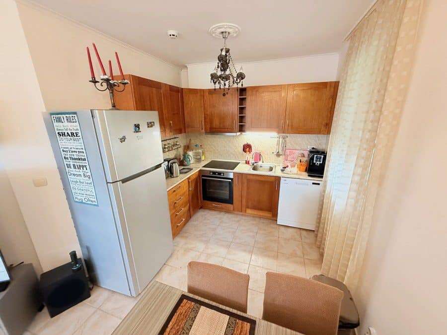 Cozy 2-Bed Ground Floor Apartment in Bulgaria Bright kitchen with wooden cabinets and modern appliances.