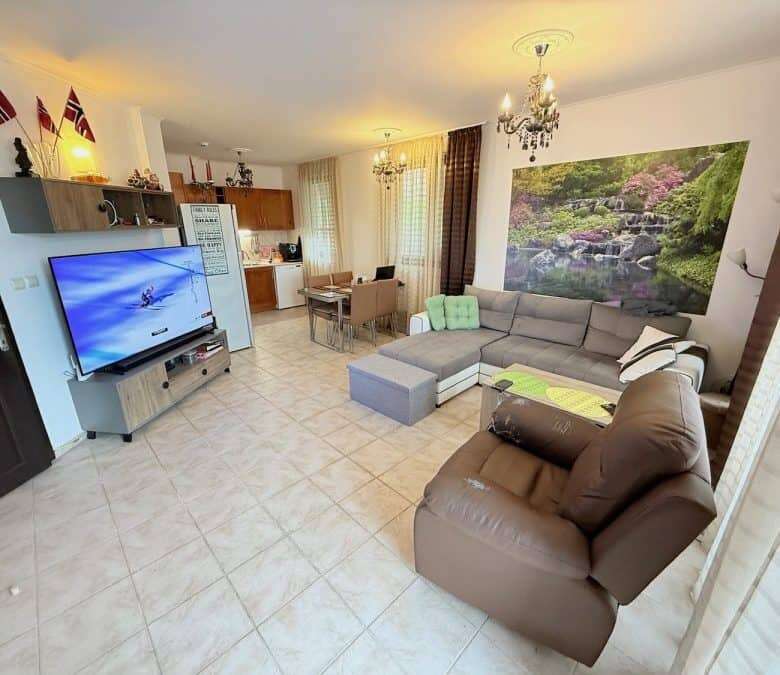 Spacious living room with modern furniture and large TV in Bay View Villas, Kosharitsa, Bulgaria.