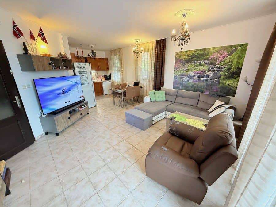 2 BED ground floor apartment in Bay View Villas Spacious living room with modern furniture and large TV in Bay View Villas, Kosharitsa, Bulgaria.