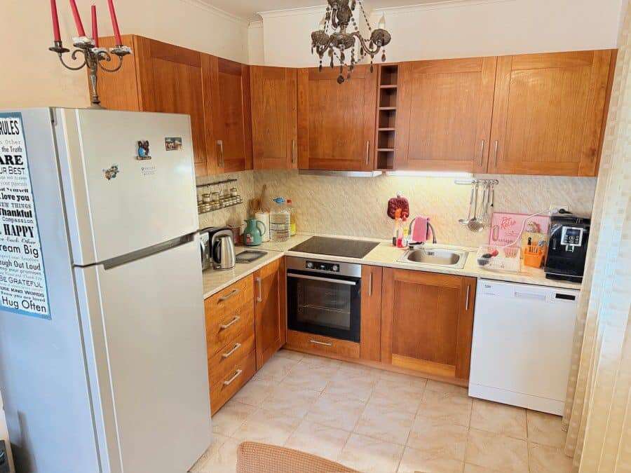 Modern kitchen in Bay View Villas, Kosharitsa, Bulgaria Bright, fully equipped ground floor apartment kitchen with wooden cabinets and essential appliances.