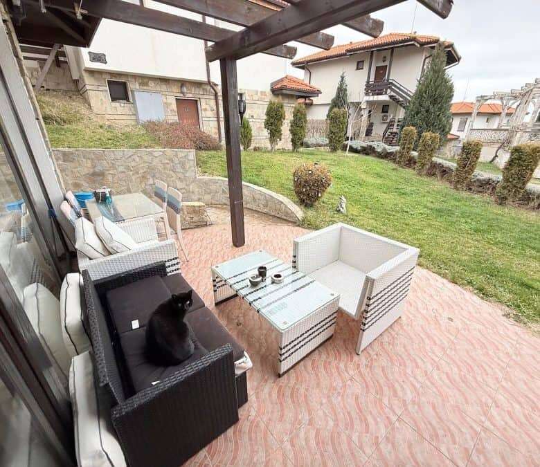 Ground floor apartment terrace with outdoor furniture and cat, near the sea in Bulgaria.