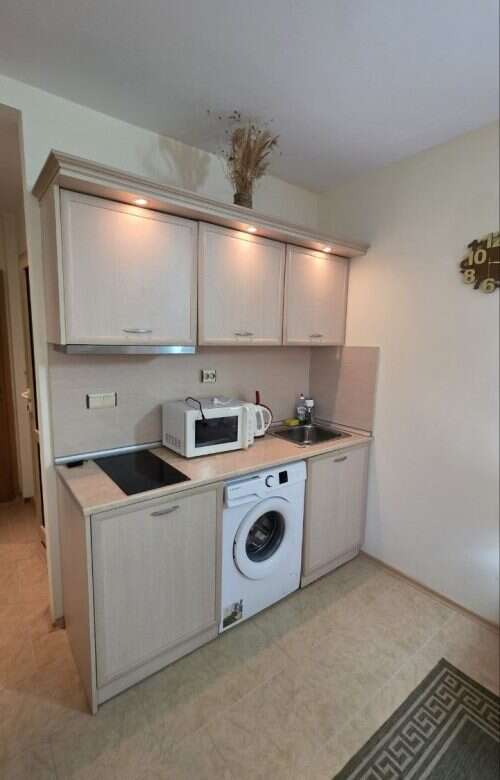 Compact kitchen in Avalon studio apartment, Sunny Beach, with washing machine and microwave.