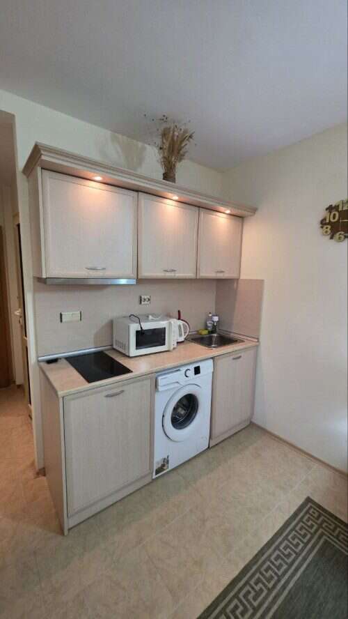 Compact kitchen in Avalon studio apartment, Sunny Beach, with washing machine and microwave.
