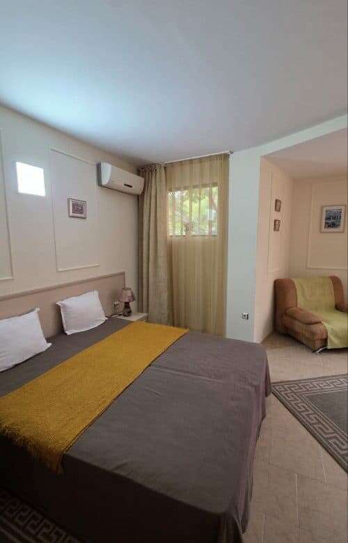 Comfortable bedroom with double bed, beige curtains, and modern decor in Avalon Sunny Beach.