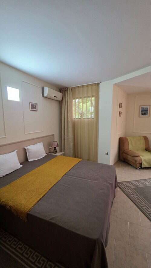 Comfortable bedroom with double bed, beige curtains, and modern decor in Avalon Sunny Beach.