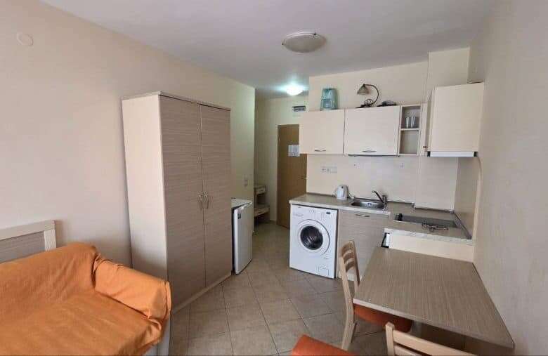 Compact studio apartment interior with kitchenette and sleeping area in Royal Sun.