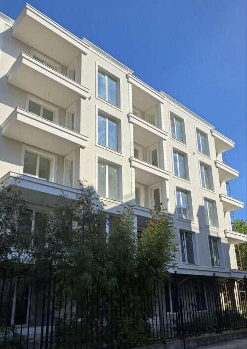 Modern white apartment building with balconies in Sunny Beach, Bulgaria, near the sea.