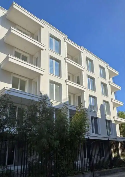 Modern white apartment building with balconies in Sunny Beach, Bulgaria, near the sea.