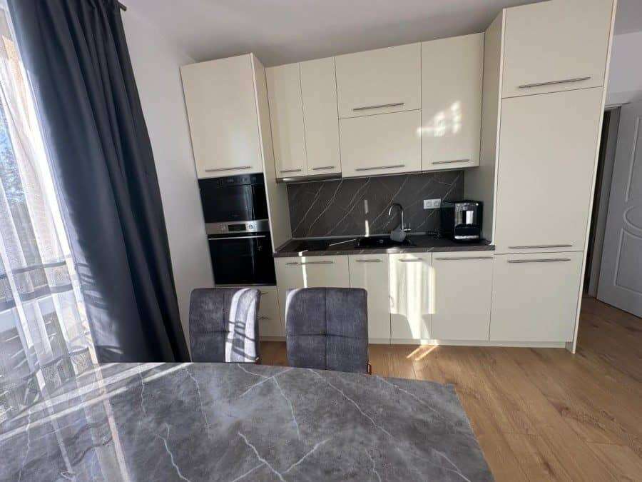 Modern kitchen with white cabinets and black countertops in a 2-bedroom apartment close to Sunny Bea.