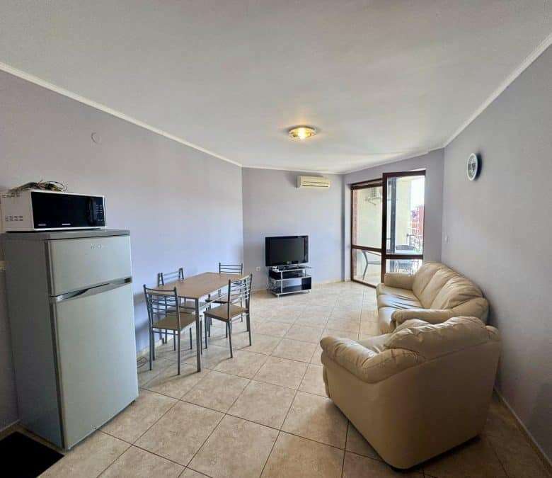 Spacious living room with pool view, featuring a sofa, dining area, and TV in Apollon 5, between Rav.