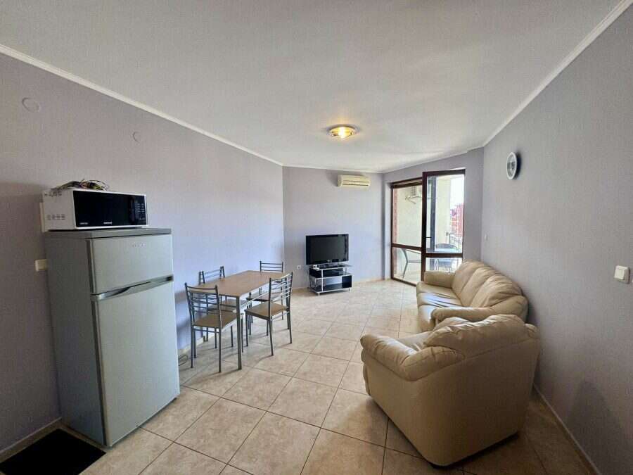 Spacious living room with pool view, featuring a sofa, dining area, and TV in Apollon 5, between Rav.